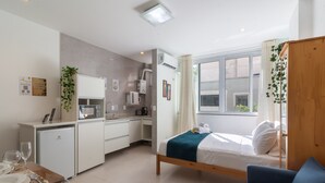 A compact room with a bed, a small kitchenette, a dining area, and a window with curtains. - 5 Minutes From Copacabana Beach Bi202 (Rio de Janeiro)