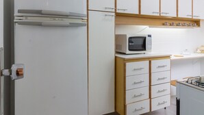 A kitchen with white cabinets, a microwave, and a refrigerator. - 4 Minutes From Leblon Beach Ga207 (Rio de Janeiro)