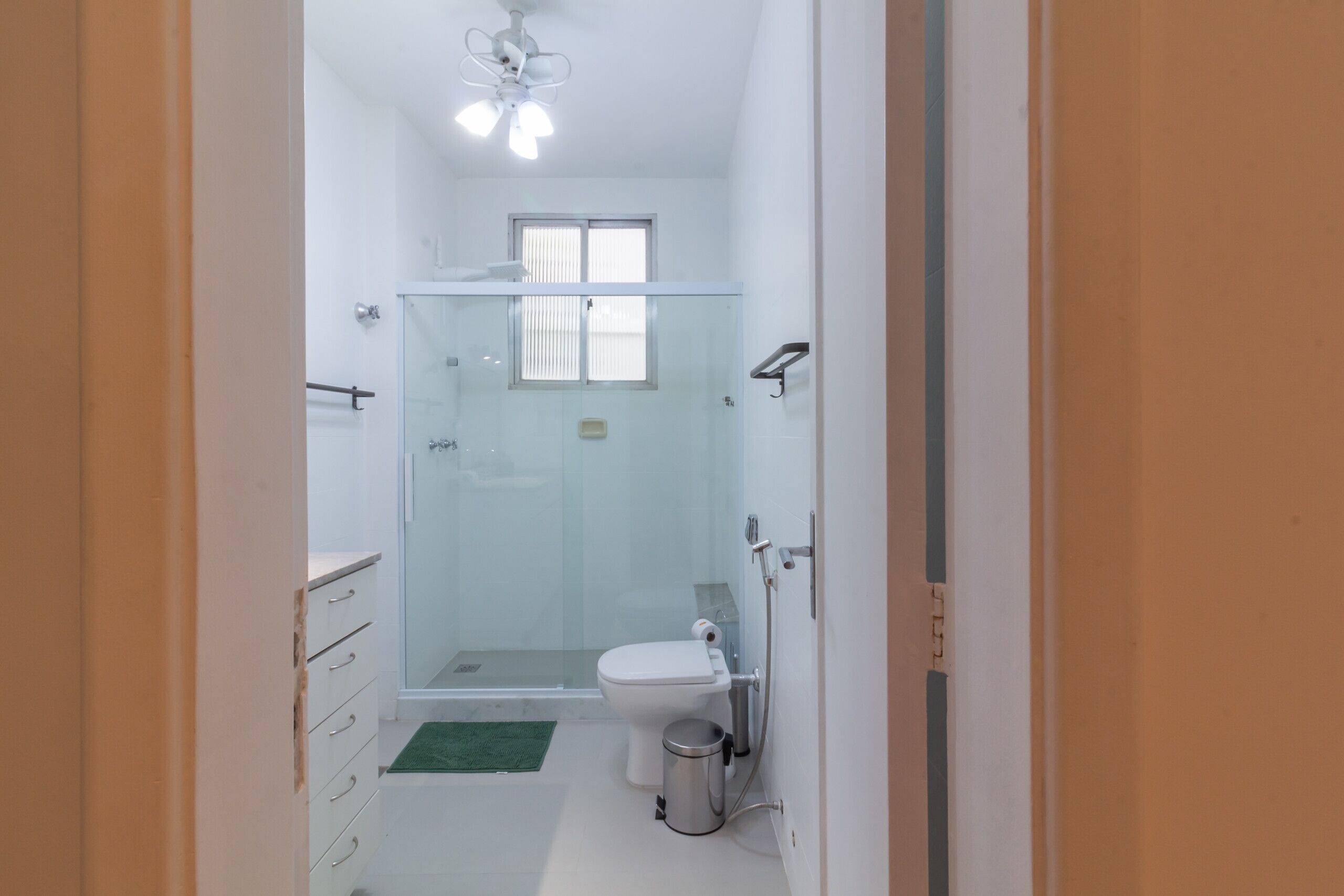 A modern bathroom with a glass shower enclosure, a toilet, and a sink.