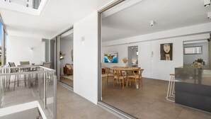 Ein moderner, offener Wohnbereich mit Essbereich, Küche und einer Glastür zum Balkon.