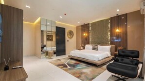 A modern bedroom with a bed, a desk, a chair, and a mirror. - Bedazzle Shortlets  (Lekki)