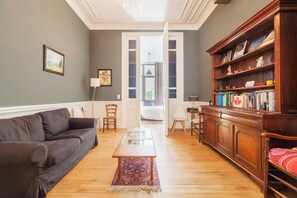 Una sala de estar con un sofá, una mesa de centro y una estantería.
