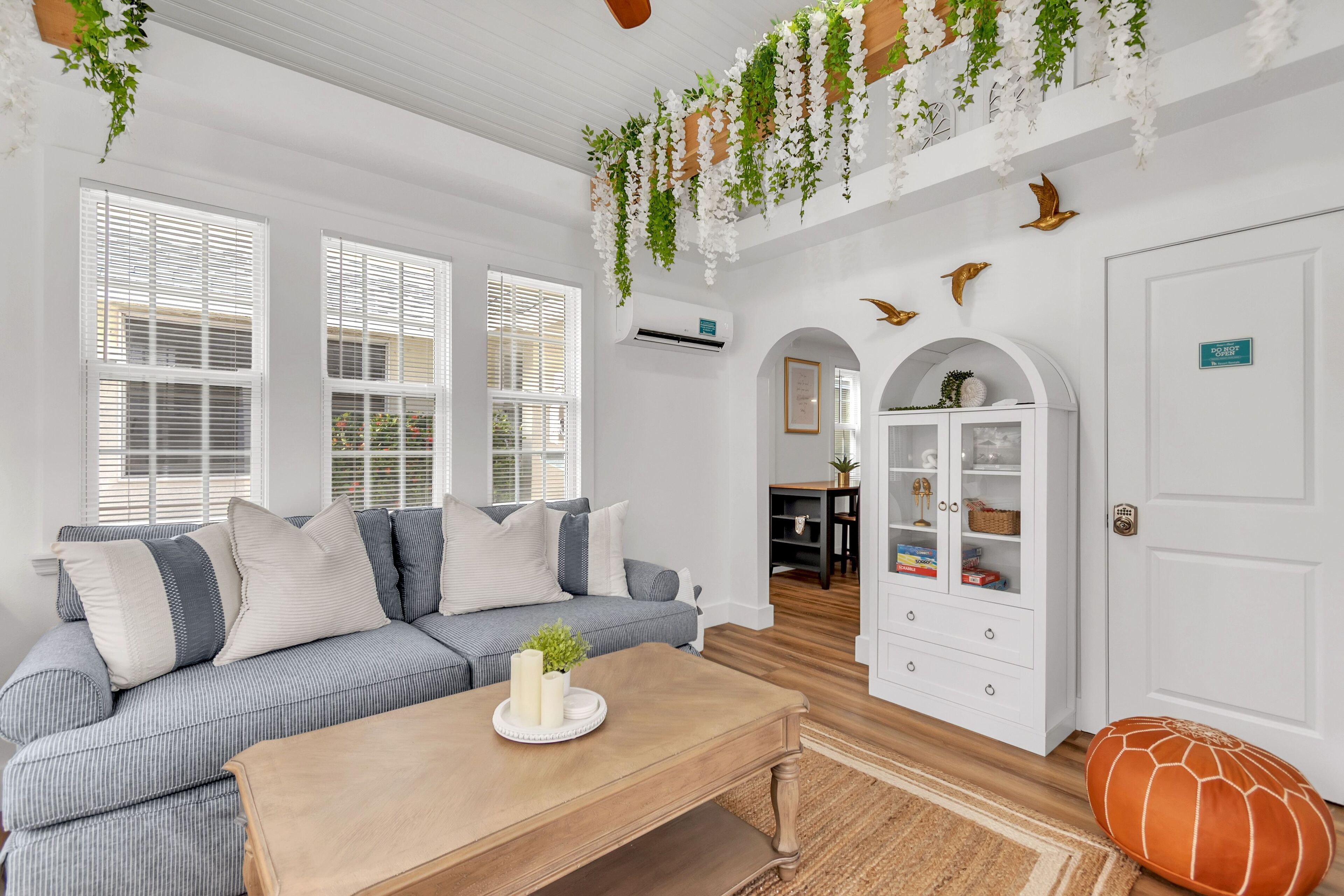 A modern living room with a grey sofa, wooden coffee table, and white walls.