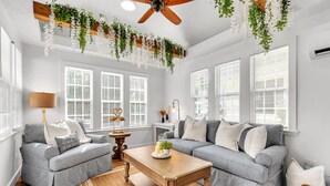 Ein Wohnzimmer mit zwei grauen Sofas, einem Holztisch und einem Deckenventilator.
