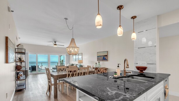 Una cucina moderna con un'ampia isola, luci a sospensione e vista all'esterno.