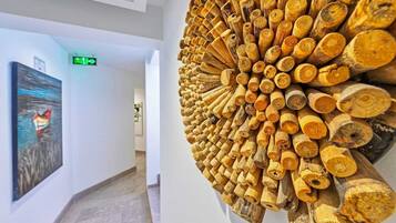 Un pasillo con una gran escultura de madera y un cuadro en la pared.
