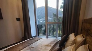 Un dormitorio con una cama grande, vistas al exterior y un balcón.