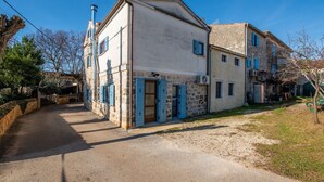 Un edificio in pietra tradizionale con un sentiero sterrato che conduce all'ingresso.