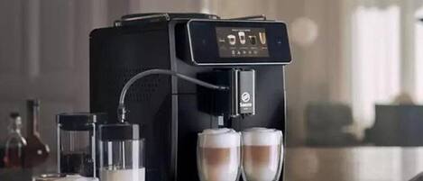 A coffee machine with two cups of coffee on a countertop.