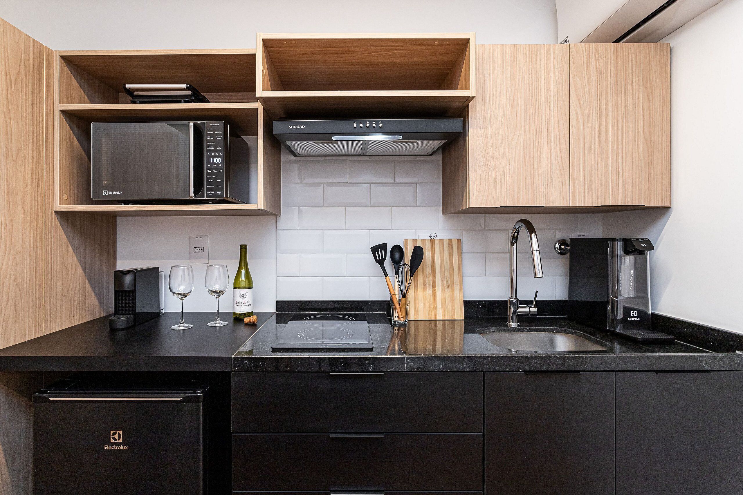A modern kitchen with a microwave, stove, and coffee maker.