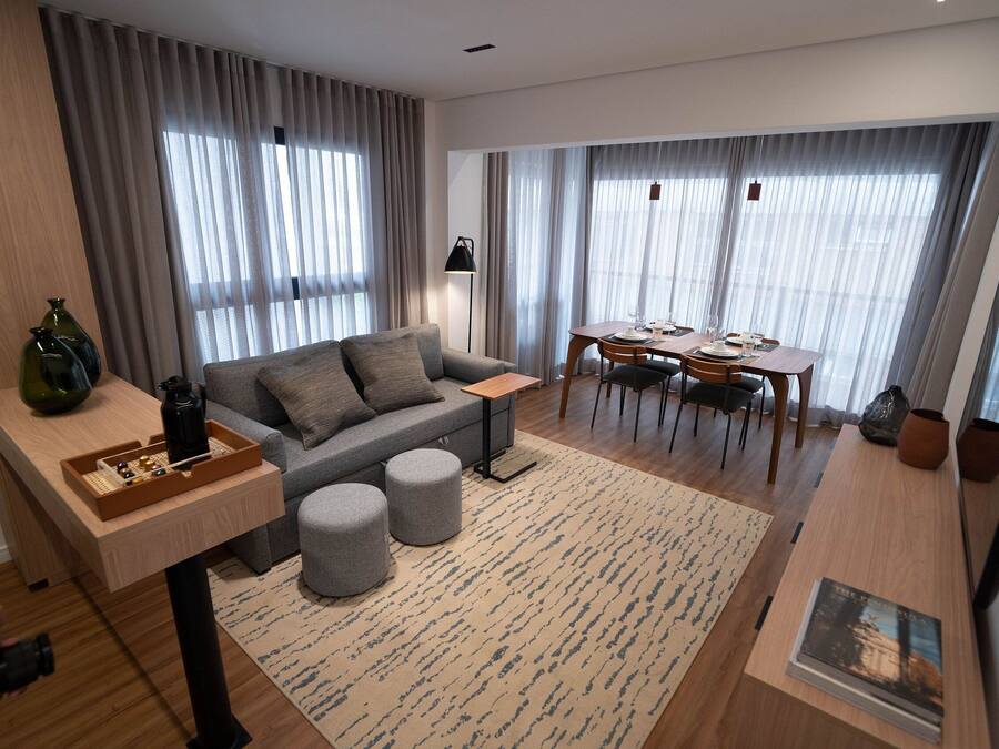 A modern living room with a sofa, ottomans, a dining table, and a coffee table.
