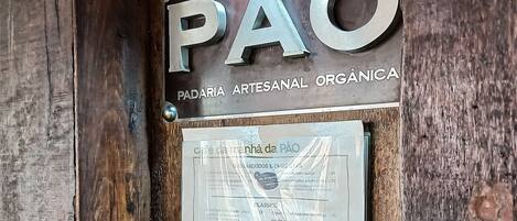 Une porte en bois avec une enseigne indiquant « PAO » et un menu.