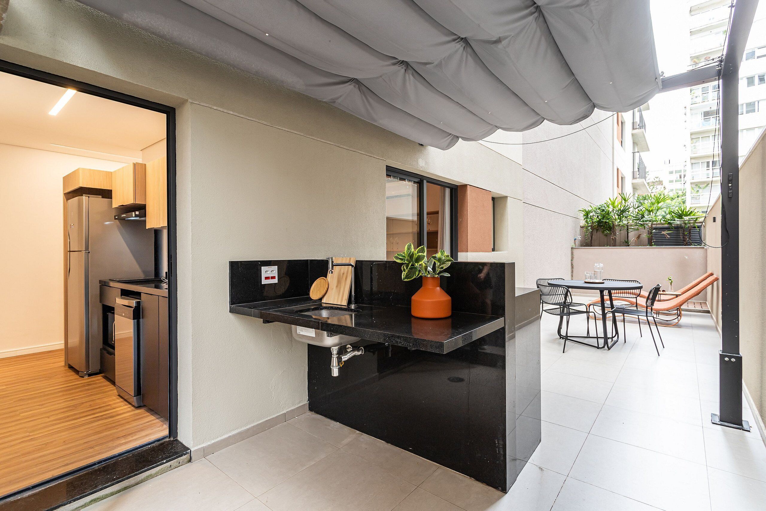 Una cocina moderna con encimera negra, un fregadero y una planta en maceta.