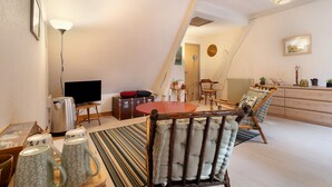 Una sala de estar acogedora con sofá, mesa de centro, televisor y un comedor con sillas y mesa.