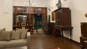 Een ruime woonkamer met een hoge nok, houten meubels en een kroonluchter.