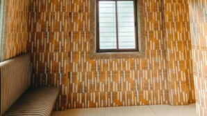 Una habitación con un papel tapiz decorativo, una ventana y un banco.