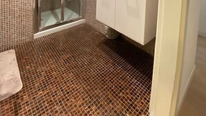 Ein Badezimmer mit Dusche, Waschbecken und Spiegel.