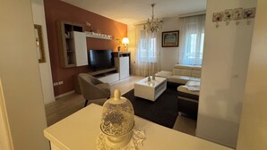 Ein Wohnzimmer mit Fernseher, Sofa und Couchtisch.