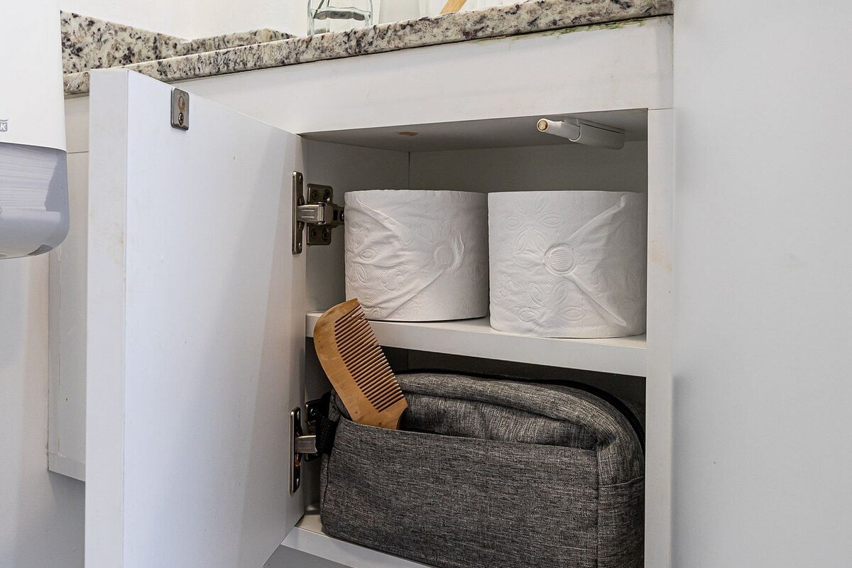 Un baño con estante integrado, cepillo de dientes y planta.