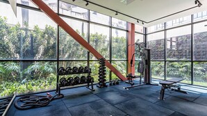 A gym with large windows, exercise equipment, and a view of greenery outside. - Urbic Vila Mariana by Viva - Prédio com academia e coworking a passos da ESPM, Belas Artes e Metrô (São Paulo)