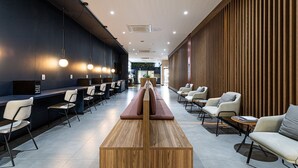 A modern lobby with a reception desk, seating area, and a wooden wall. - Urbic Vila Mariana by Viva - Prédio com academia e coworking a passos da ESPM, Belas Artes e Metrô (São Paulo)