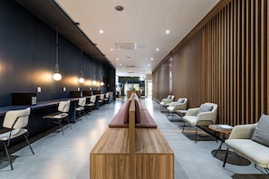 Un vestíbulo moderno con mostrador de recepción, zona de estar y pared de madera.