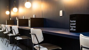 A reception area with a dark wall, multiple light fixtures, and a sign that reads 'home sweet home office.' - Urbic Vila Mariana by Viva - Prédio com academia e coworking a passos da ESPM, Belas Artes e Metrô (São Paulo)