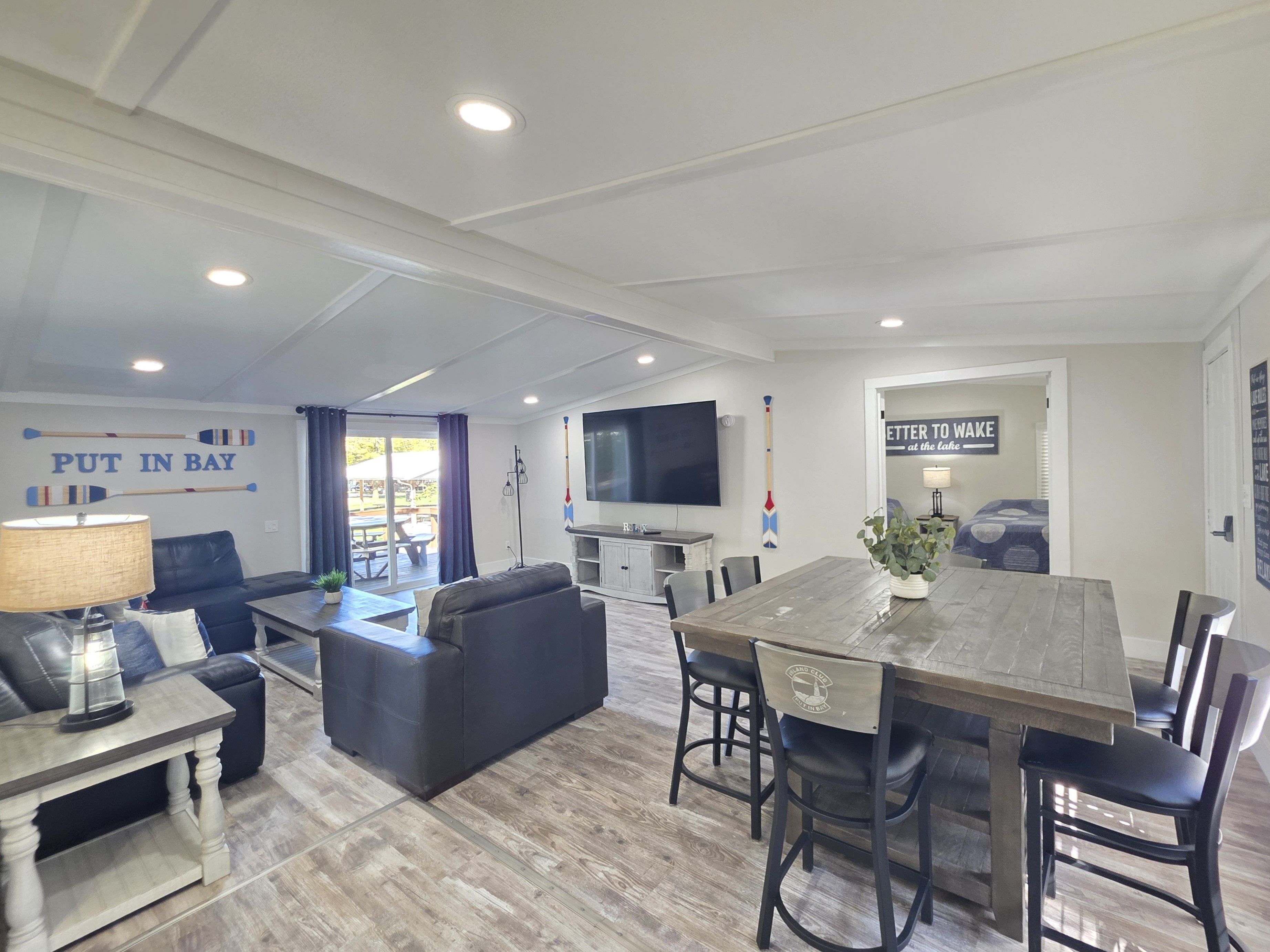 A modern living room with a sofa, coffee table, and a dining area with a wooden table and chairs.