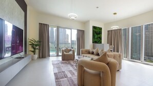 A modern living room with a large flat-screen TV, comfortable sofas, a coffee table, and a potted plant. - 3BHK Sea View Near Palm Jumeirah Avani  (Dubai)