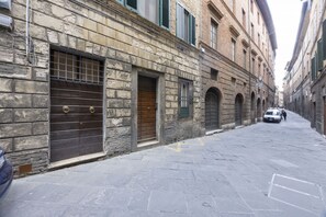 A narrow street with stone buildings, closed shop fronts, and a parked car. - Cozy apartment in the historic center of Siena, located in the Contrada del Leocorno.It can accommodate up to 6 guests with two double bedrooms and a room with a bunk bed and desk. Equipped with a fully equipped kitchen, Wi-Fi, TV, washing machine, linen (Siena)