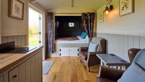 Ein gemütliches Interieur mit einem Bett, einer Essecke und einer Küche.