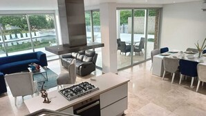 Una cocina moderna con estufa a gas, horno empotrado y comedor con mesa y sillas.
