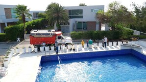 A pool area with a water truck and people around it. - RESORT FRENTE AL MAR (Juan de Acosta)