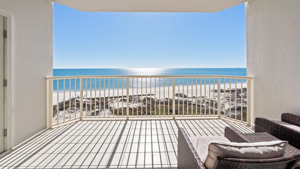 A balcony with a view of the beach, a white railing, and wicker furniture. - Beach Club 1109 D (Gulf Shores)