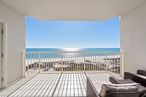 A balcony with a view of the beach, a white railing, and wicker furniture. - Beach Club 1109 D (Gulf Shores)
