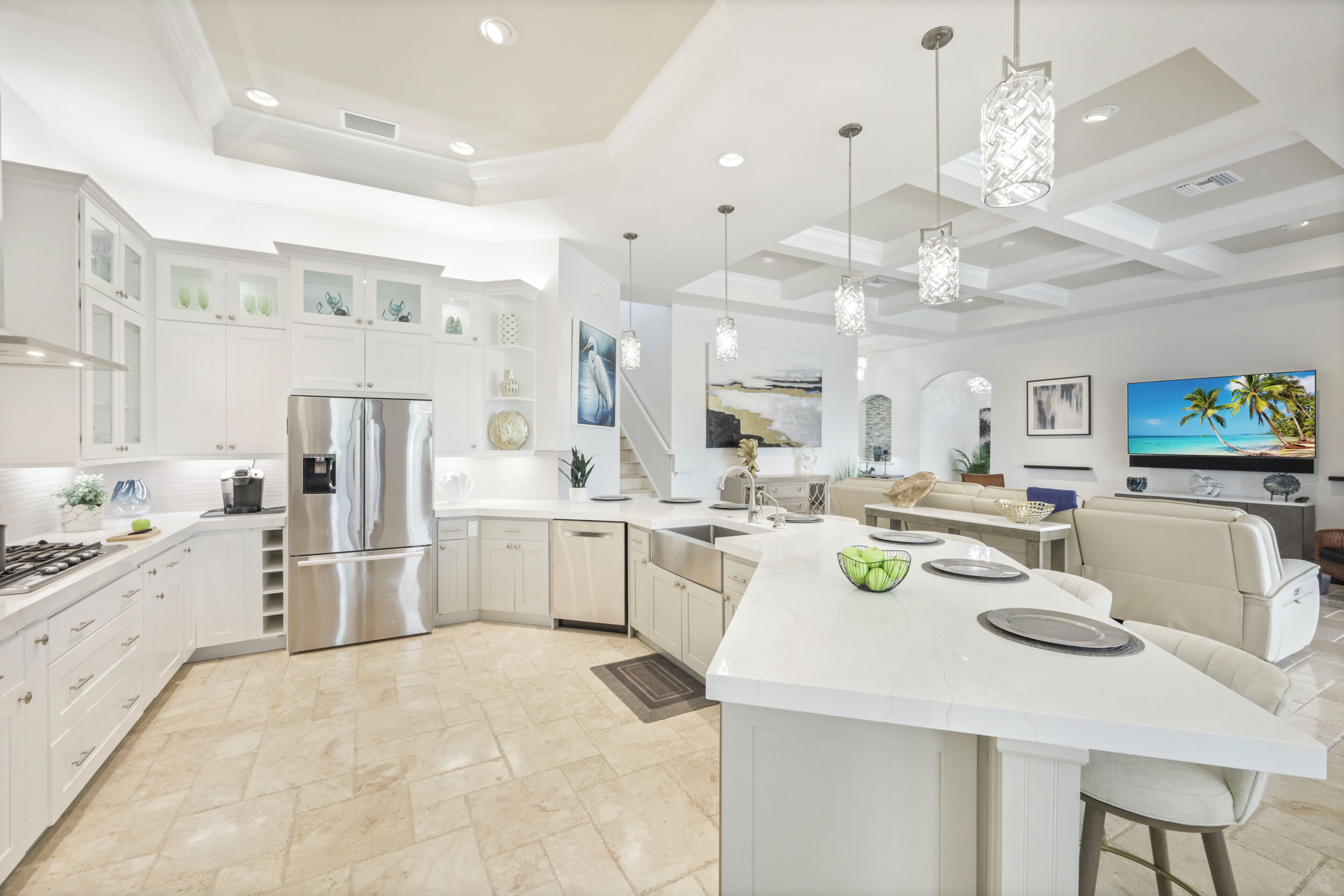A modern kitchen with a central island, stainless steel appliances, and pendant lighting.
