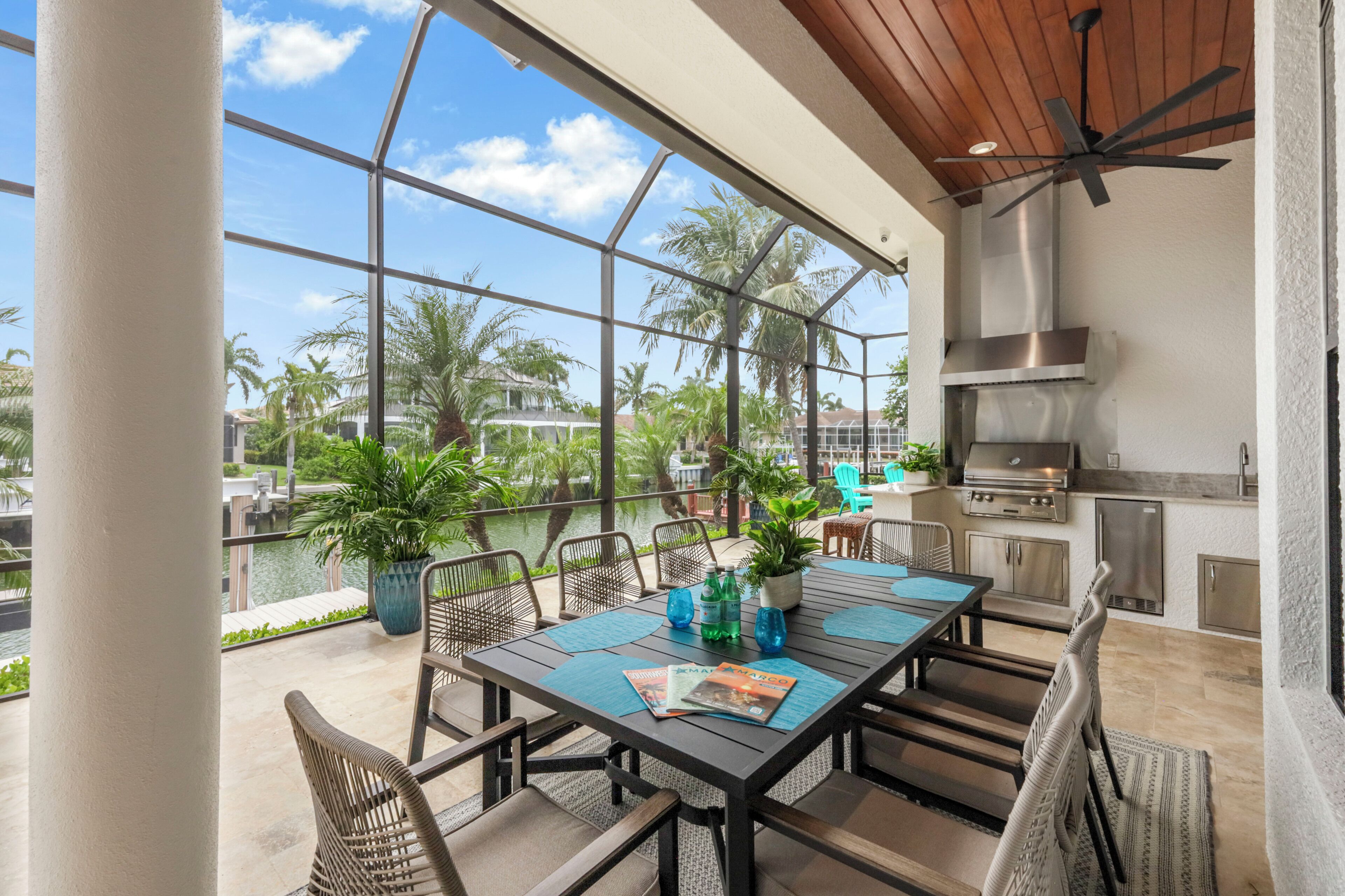 Une terrasse extérieure avec une table à manger, des chaises et un espace barbecue.