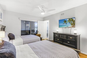 A bedroom with two beds, a ceiling fan, a TV on the wall, and a dresser. - The Somerset Solace | Pools, Tennis Courts & Gym (Marco Island)