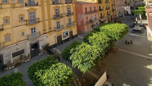 A street view with buildings, trees, and outdoor seating. - Manu's house B&B (Porto Empedocle)