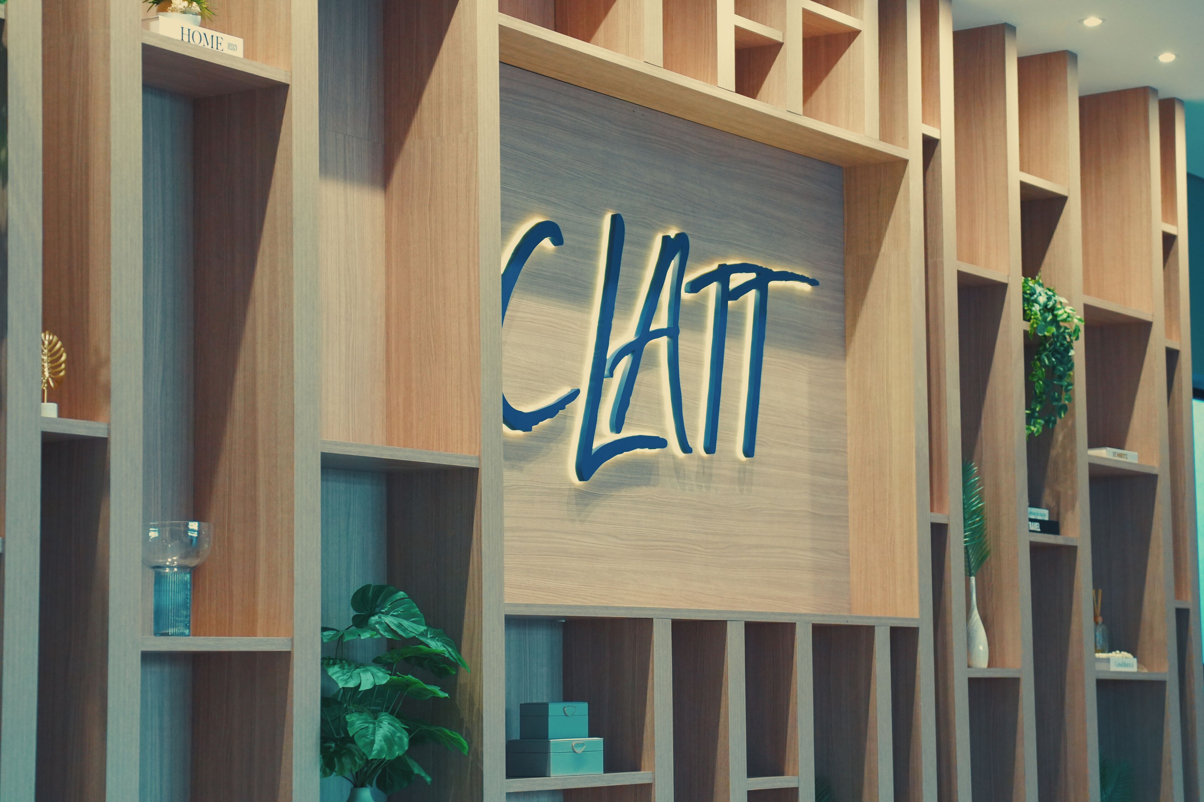 A modern interior with a prominent sign reading 'CLATT' on a wooden panel.