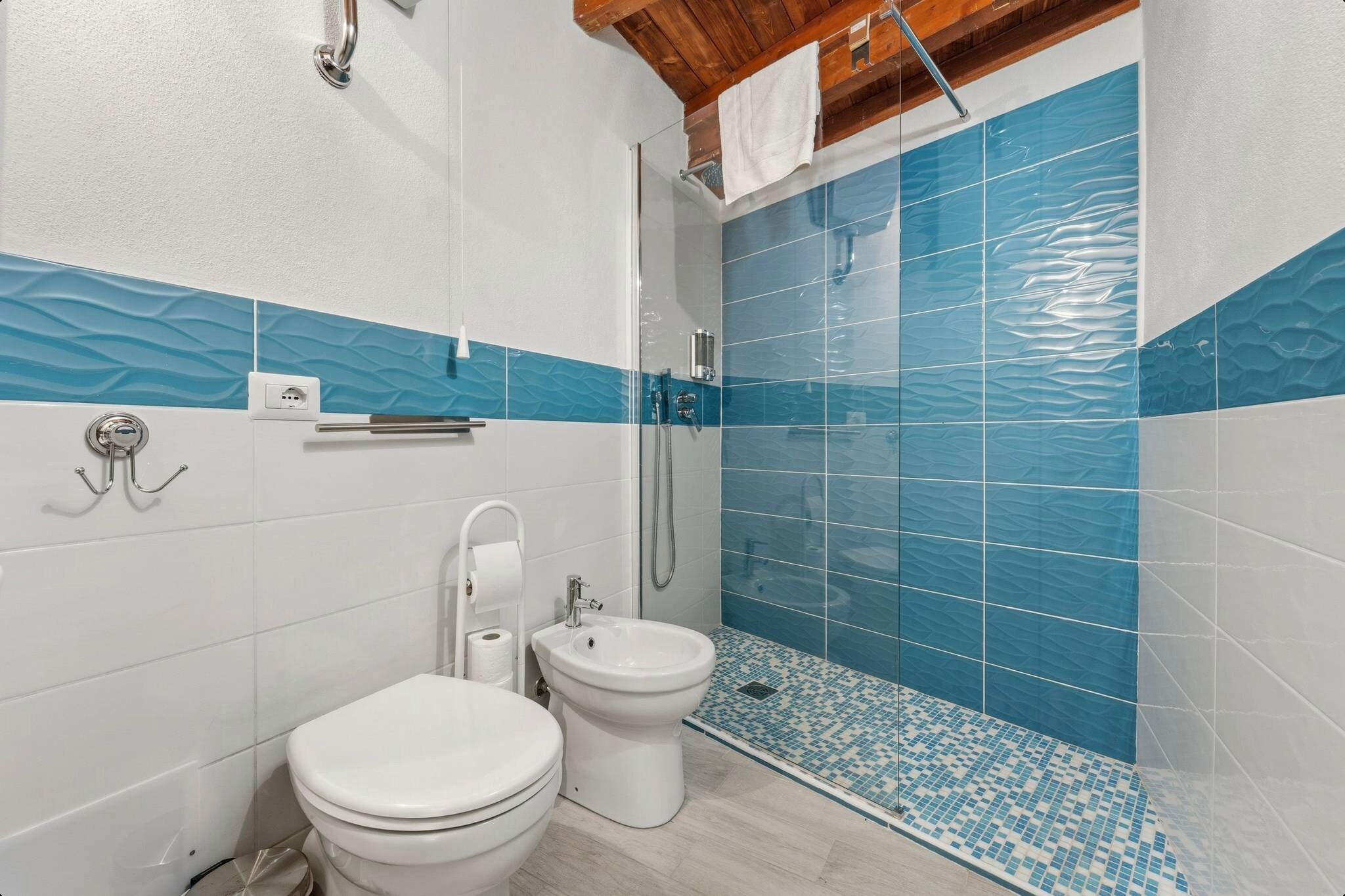 A bathroom with a toilet, bidet, and shower area.