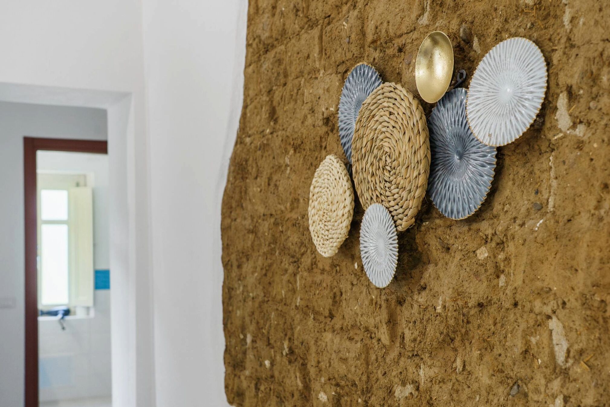 A textured wall with woven and metallic decorative elements.