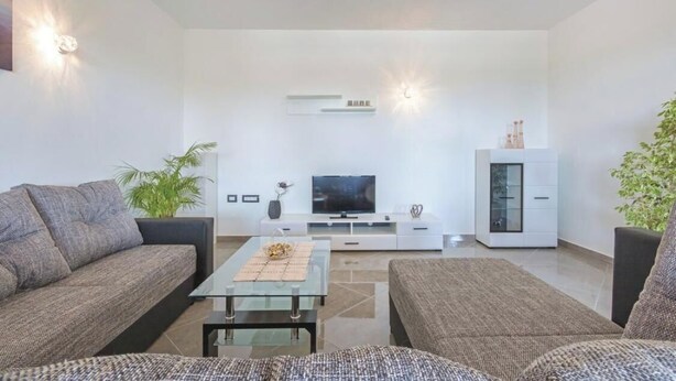 A modern living room with a sofa, a coffee table, a TV, and a cabinet. - Heritage Pool Retreat Castinella - D1 (Pula)