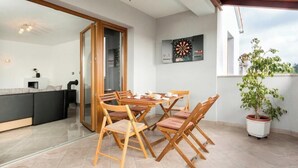 A dining area with wooden chairs and a table, a dartboard, and a potted plant. - Heritage Pool Retreat Castinella - D1 (Pula)