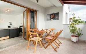 A dining area with wooden chairs and a table, a dartboard, and a potted plant. - Heritage Pool Retreat Castinella - D1 (Pula)