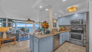 A spacious kitchen with granite countertops, stainless steel appliances, and a view to the outside. - Panoramic Oceanfront View, Breathtaking Sunsets, Relax on Large Lanai (Lahaina)