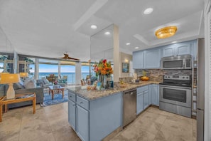 A spacious kitchen with granite countertops, stainless steel appliances, and a view to the outside. - Panoramic Oceanfront View, Breathtaking Sunsets, Relax on Large Lanai (Lahaina)