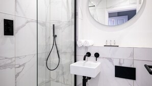 A modern bathroom with a glass-enclosed shower, a white sink, and a toilet. - Dalton Apartment 2 (Lancaster)