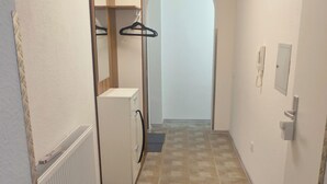 A narrow hallway with a radiator, a small refrigerator, and a door leading to another room. - Vacation on the Rhine Speyer Hockenheim Mannheim (Altlußheim)