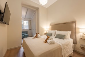 A hotel room with a large bed, a TV mounted on the wall, and a view of a balcony. - Holiday Home 'Silvia Home Suite' elegant residence with private garden in the heart of Palermo (Palermo)
